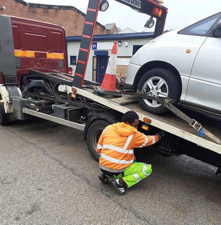 Operator securing a vehicle with straps